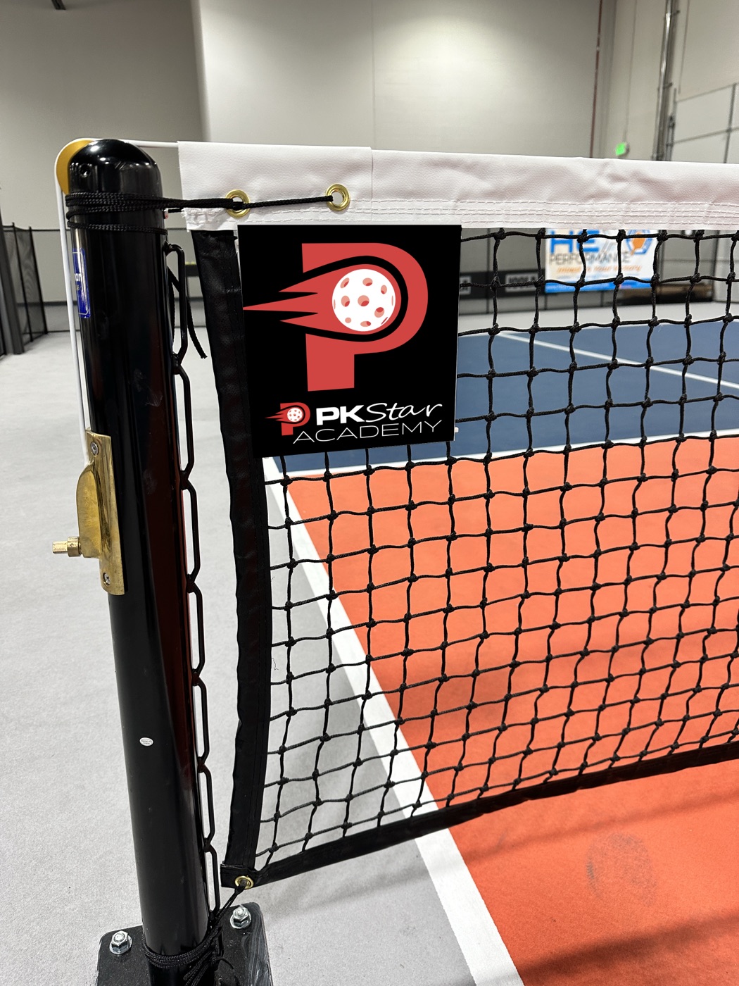 PK Star Academy logo on the net and court